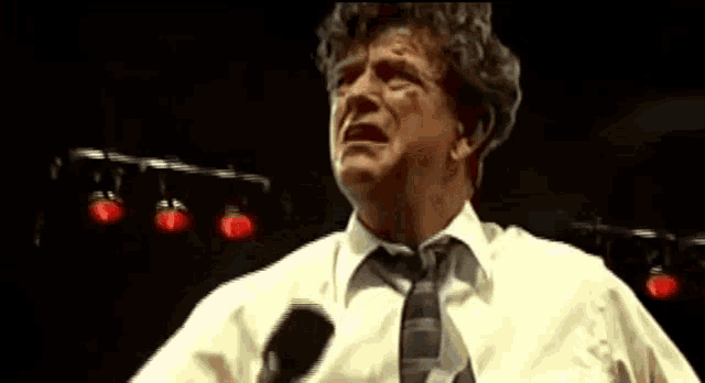 a man in a white shirt and tie is crying