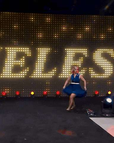 a woman in a blue dress is running on a stage in front of a large sign that says ez