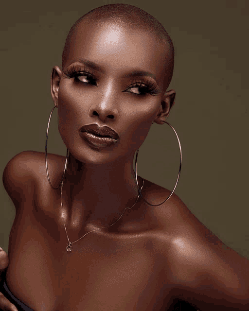 a close up of a woman 's face with a necklace and hoop earrings