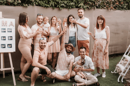 a group of people toasting in front of a sign that says ma on it