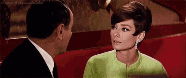 a man and a woman are looking at each other in a room .
