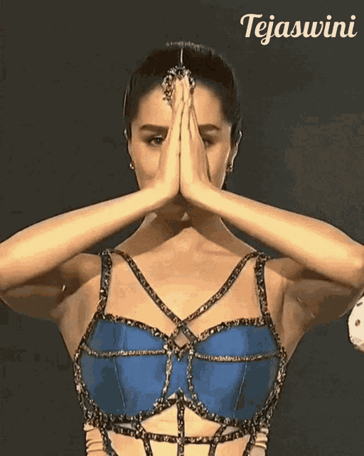 a woman with her hands folded in front of her face and the name tejaswini written above her