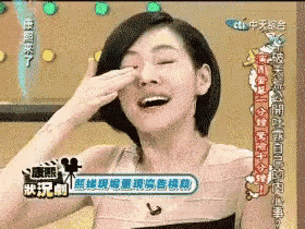 a woman is laughing and covering her eyes with her hand in front of a sign that says cti