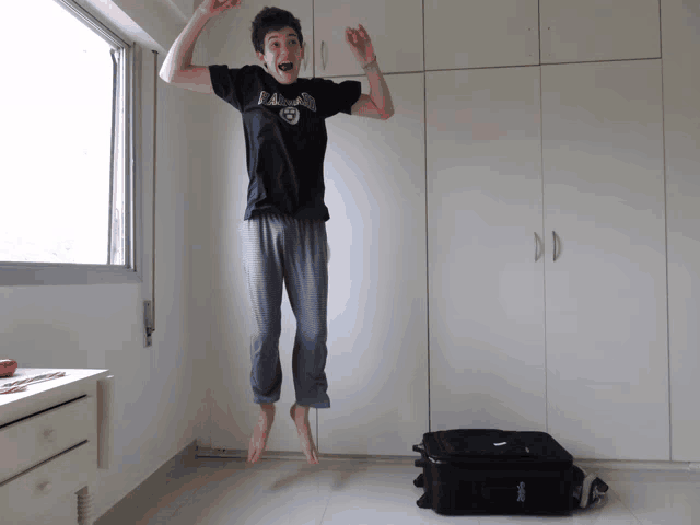 a man jumping in the air with a raiders shirt on