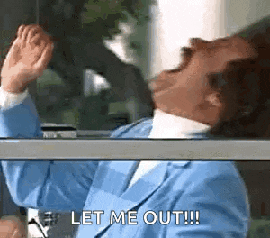 a man in a blue suit is sitting in front of a window and screaming .