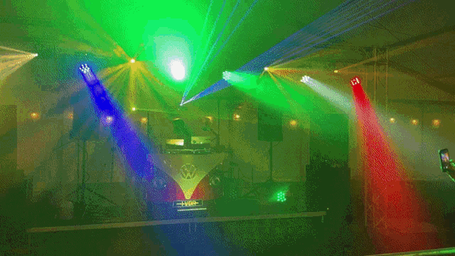 a stage with a vw bus on it and a dj behind it