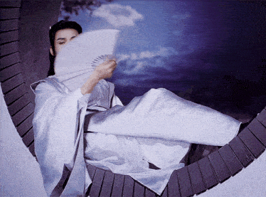 a person in a white robe is holding a fan