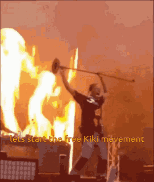 a man holding a stick in front of a fire with the words lets start the free kiki movement