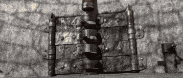 a close up of a metal door with a brick wall behind it