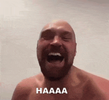 a shirtless man with a beard is laughing with his mouth open and the word haaaa written on his face .