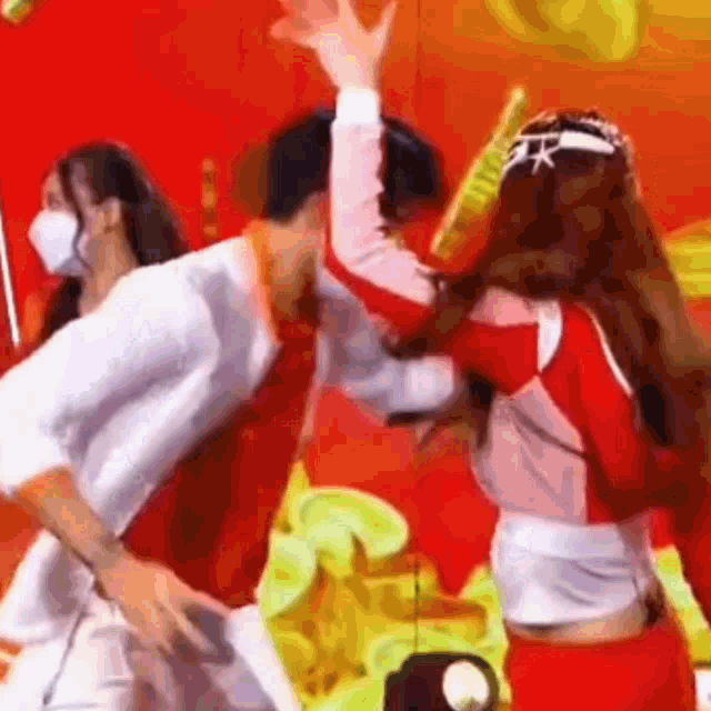 a man and two women are dancing on a stage while wearing masks .