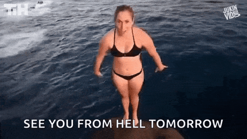 a woman in a bikini is jumping into a body of water .