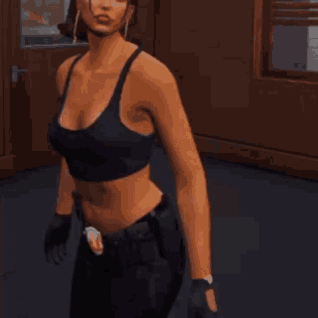 a woman in a crop top and gloves is standing in a room .