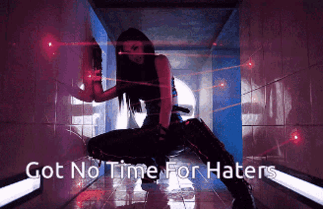 a woman is kneeling down in a hallway with the words got no time for haters behind her