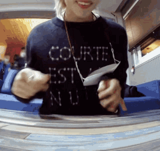 a woman wearing a black shirt that says courte est nu
