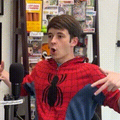 a man in a spiderman costume is standing in front of a microphone with his hands outstretched