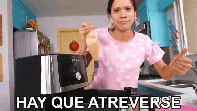 a woman in a pink shirt is cooking in a kitchen and the words hay que atreverse are visible