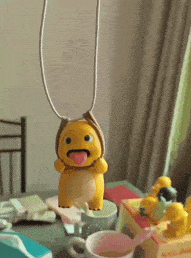 a yellow stuffed animal with a tongue sticking out is sitting on a table