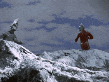 two monsters standing on top of a snow covered mountain