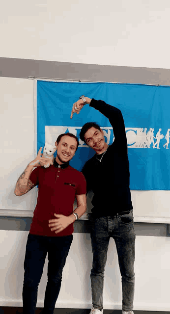 two men are posing for a picture in front of a blue banner that says ' champs '