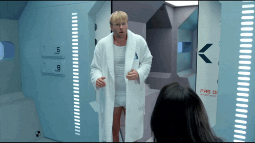 a man in a white robe stands in front of a door that says pas de