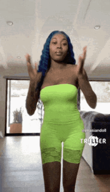 a woman in a neon green jumpsuit is standing in a living room