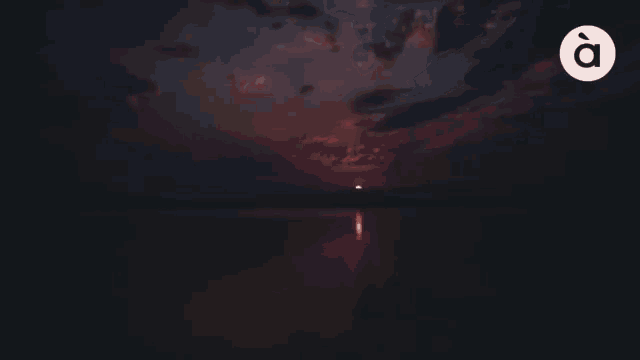 a sunset over a body of water with the letter o in the middle