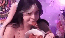 a woman is eating a bowl of spaghetti with a fork .