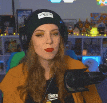 a woman wearing headphones and a beanie has a patch on her hat that says ' no fat '