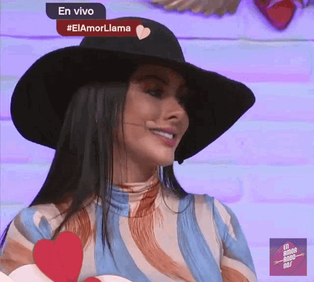 a woman wearing a hat with a heart on it and the words en vivo #elamorlama