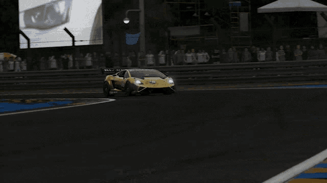a yellow sports car is driving down a track