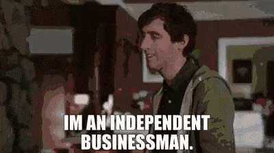 a man is standing in a living room holding a glass of wine and saying `` i 'm an independent businessman . ''