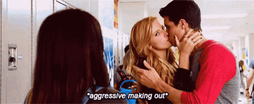 a man and a woman are kissing in a hallway while another woman watches .