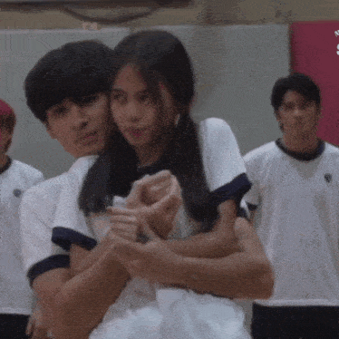 a man and a woman are hugging each other in front of a group of people
