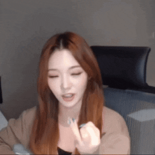 a woman with long red hair is sitting in front of a computer screen