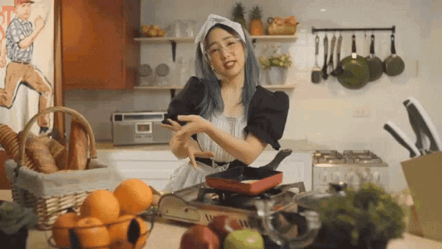 a woman in a maid costume is cooking in a kitchen and looking at her phone