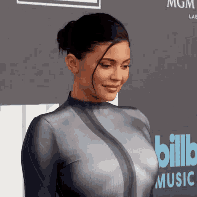 a woman is standing on a red carpet in front of a billboard .
