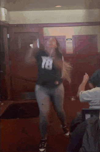 a woman with the number 78 on her shirt is dancing