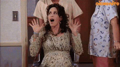 a pregnant woman is sitting in a wheelchair with her mouth open ..