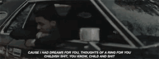 a man is driving a car with the words " cause i had dreams for you " on the side