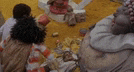 a group of people are sitting around a table with a bunch of toys on it .