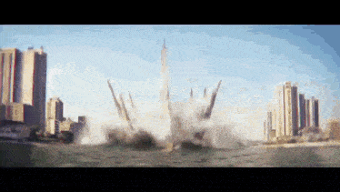 a large explosion in the middle of a city with buildings in the background