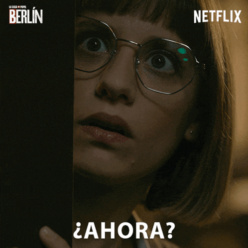 a woman wearing glasses is peeking out from behind a door with a netflix logo behind her