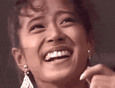 a close up of a woman 's face with a big smile on her face .