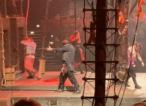 a man in a pirate outfit stands on a stage with other people