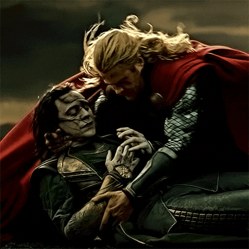 a man in a red cape is holding another man in a green suit
