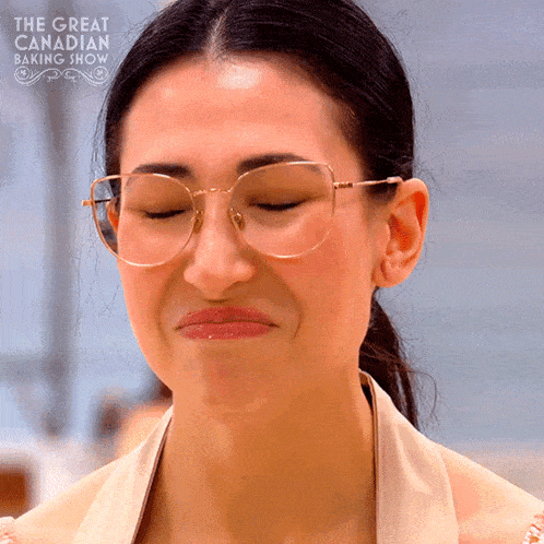 a woman wearing glasses is on the great canadian baking show making a funny face