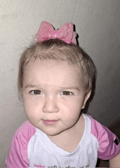 a baby girl with a pink bow in her hair