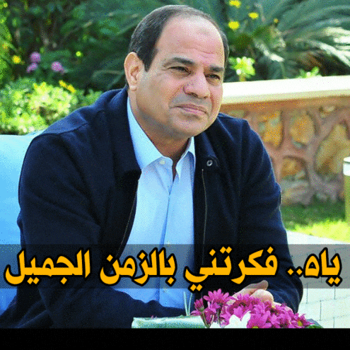 a man in a blue jacket sits in front of a sign that says ' egyptian '