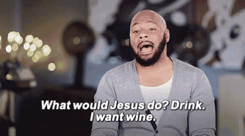 a man with a beard is saying what would jesus do ? drink i want wine .